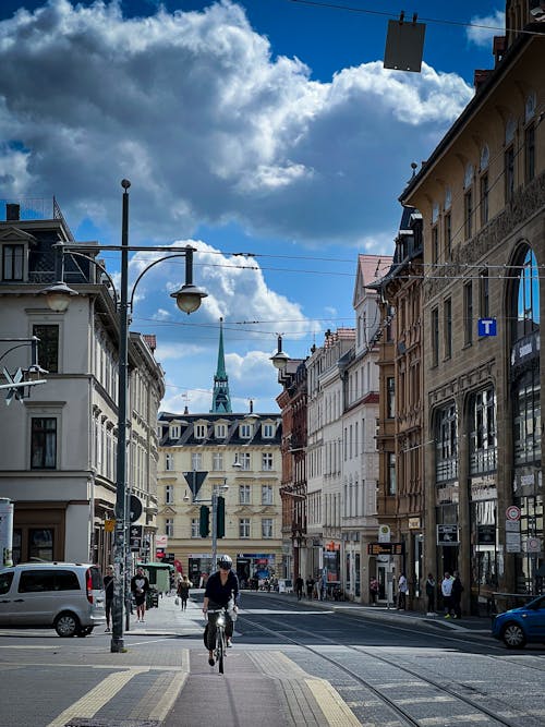 Person Riding Bicycle on Street Near Buildings