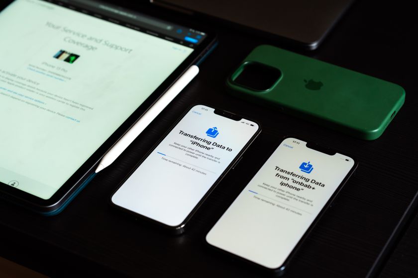 An iPad and iPhones on a desk during device setup and data transfer