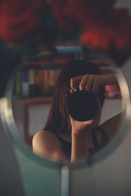 Woman Taking Photos in Front of a Mirror