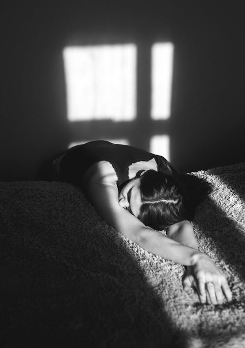 Free Grayscale Photo of a Woman Lying on the Bed Stock Photo