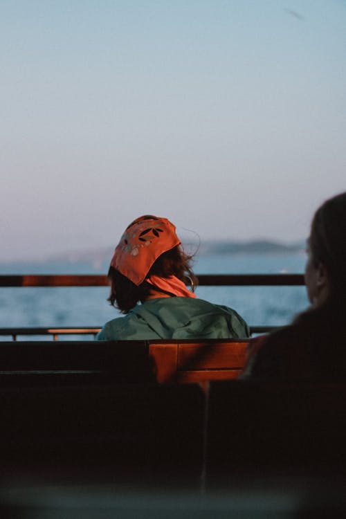 Woman In Bandana Sitting By The Sea