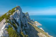 Stunning landscape of the Rock of Gibraltar with a clear blue sky and ocean.