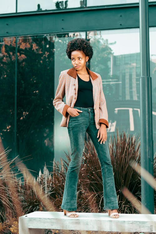 Woman in Brown Blazer and Denim Jeans Posing With Hand in Pocket 