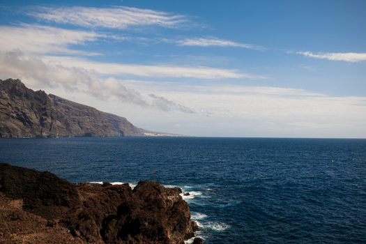 Stunning coastal landscape of Los Gigantes cliffs with clear blue sky and Atlantic Ocean.