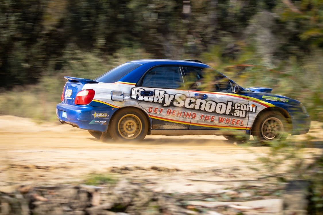 Free Blue Car Racing on Dirt Road Stock Photo
