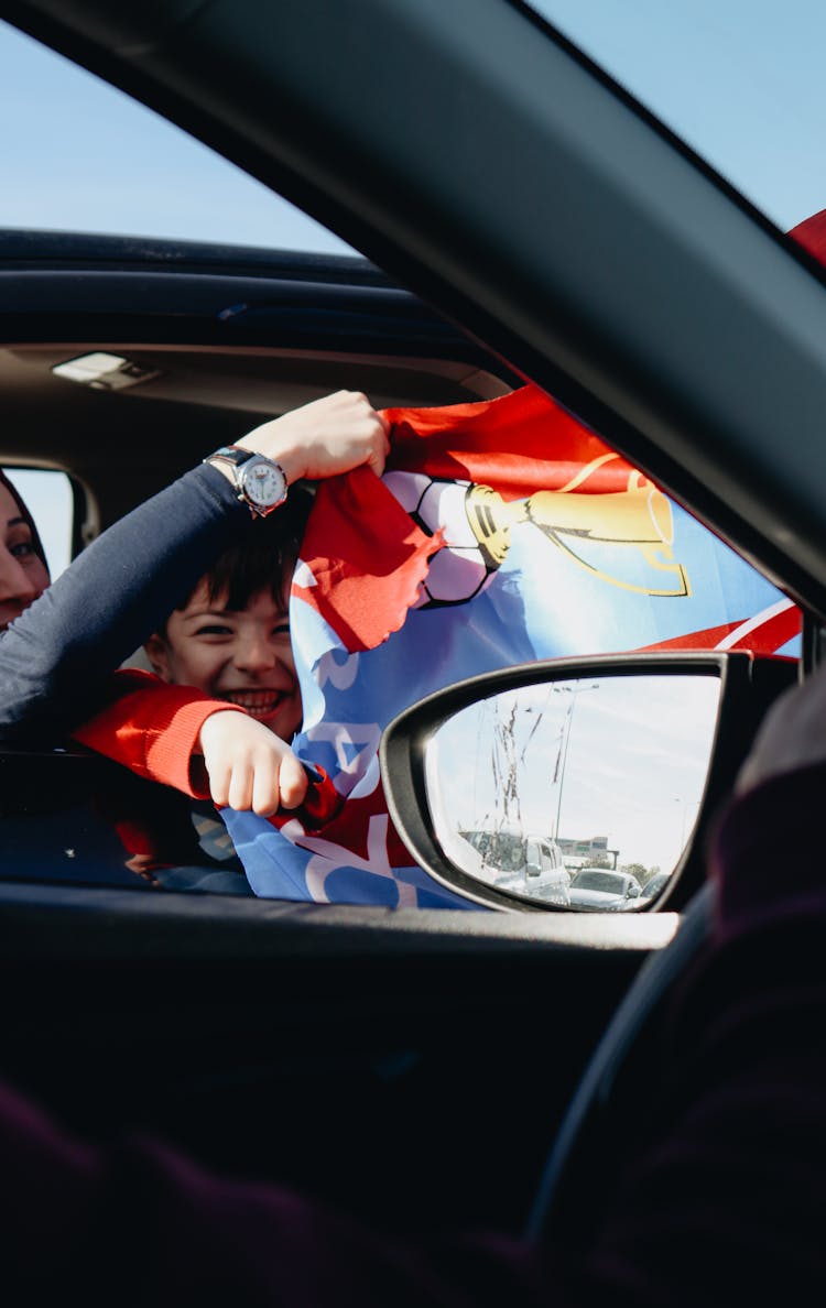 Happy Boy With Flag In Car