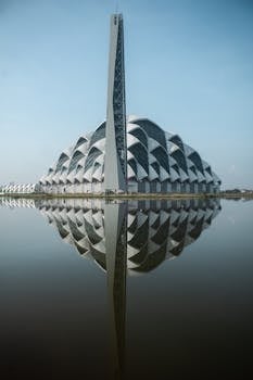 A stunning view of Masjid Raya Al Jabbar in Bandung, Indonesia, with its reflection in a calm body of water.