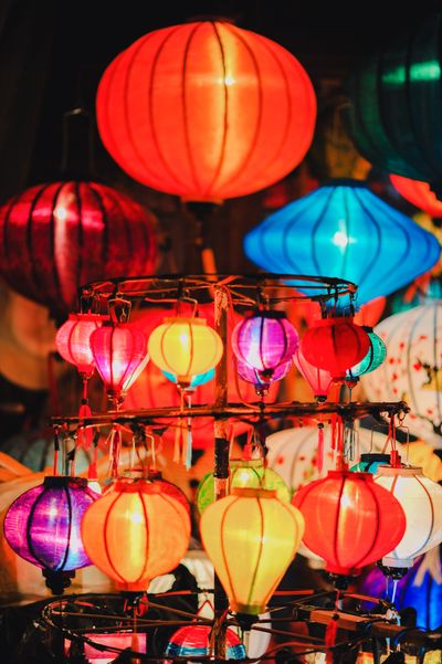 Paper lanterns strung above a walkway at night — photo by Min An on Pexels