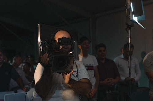 Man in White T-shirt Holding Black Dslr Camera