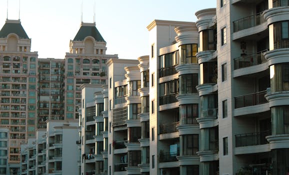 Sunlit modern apartment buildings in urban setting, showcasing unique architectural design.
