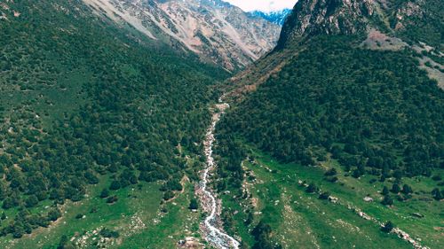Free Scenic aerial view of Chunkurchak Valley's lush greenery and rugged mountains in Kyrgyzstan. Stock Photo