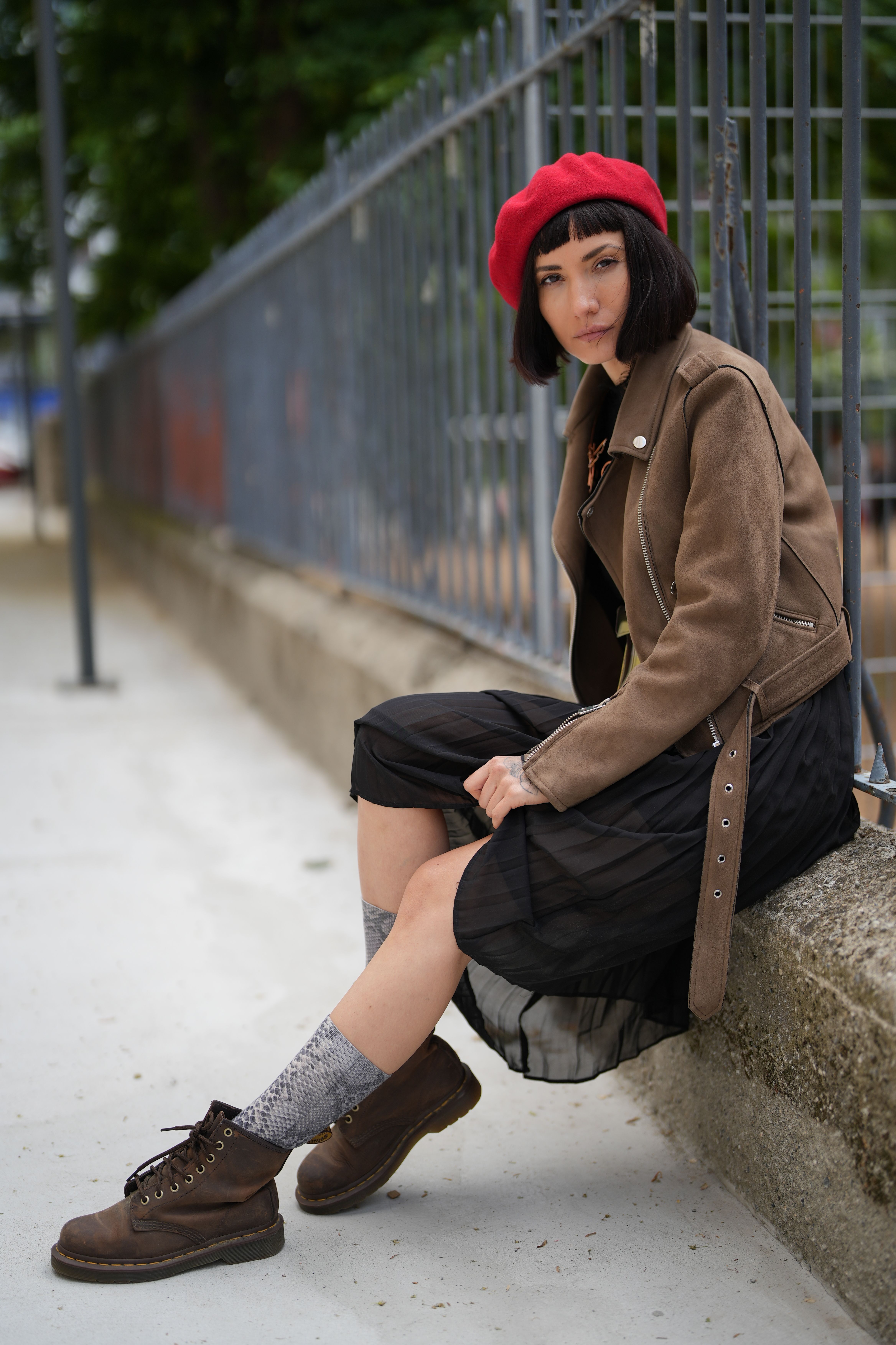 Woman in Brown Coat Sitting on Concrete Bench · Free Stock Photo