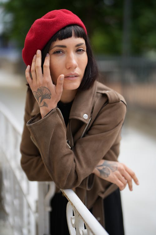 Woman in a Red Beret with Tattoos on Her Hands 