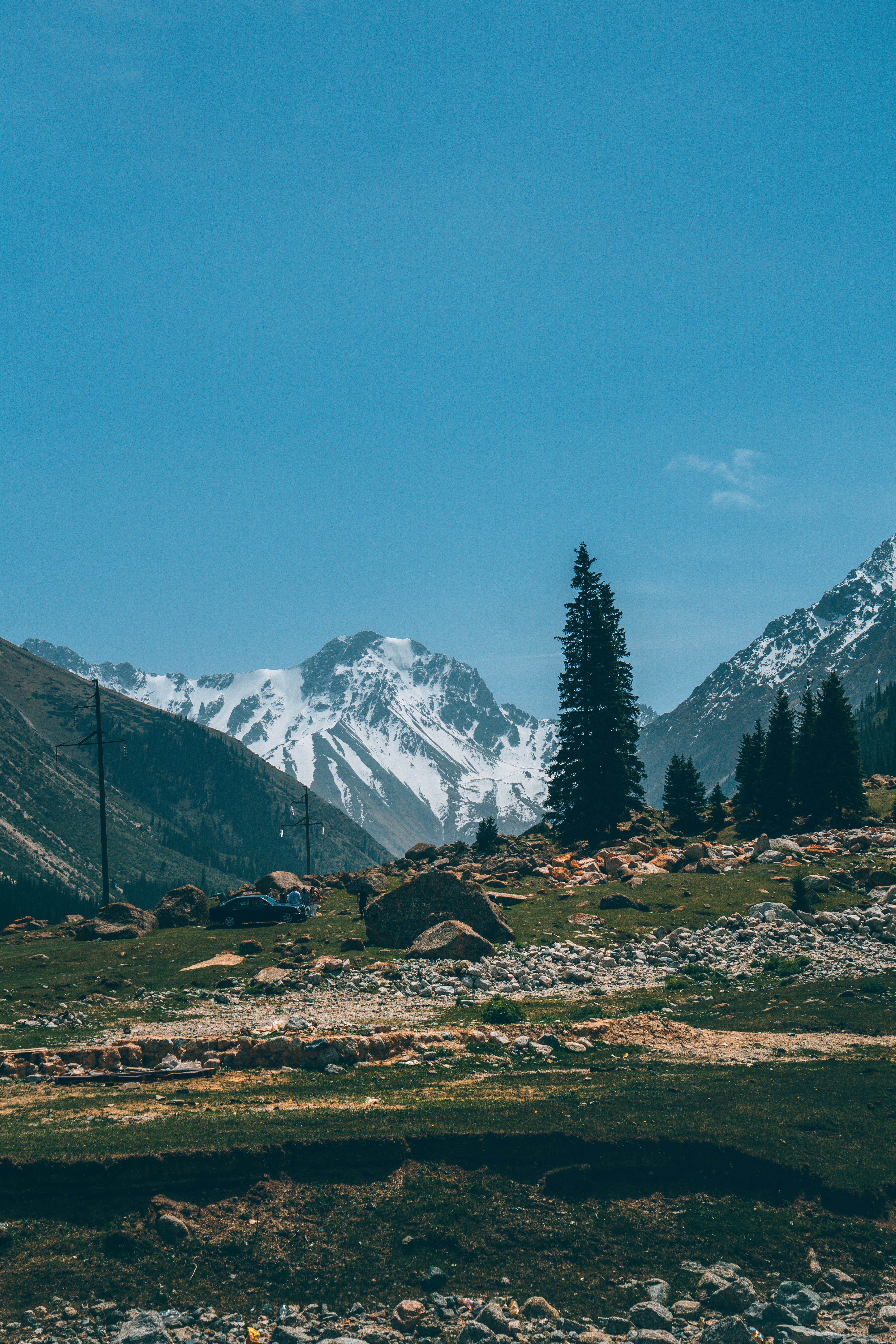 Explore the stunning contrast of snow-covered mountains against a clear blue sky in this serene landscape.