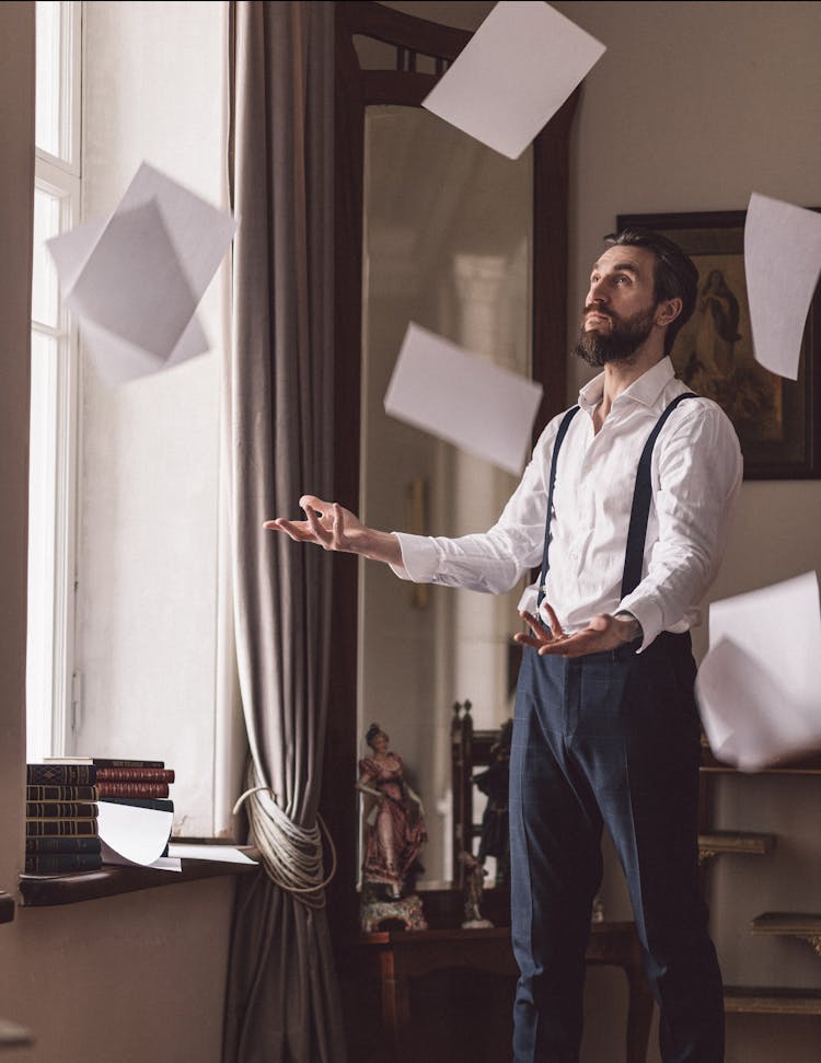 Man In White Long Sleeves And Black Pants Throwing Papers 