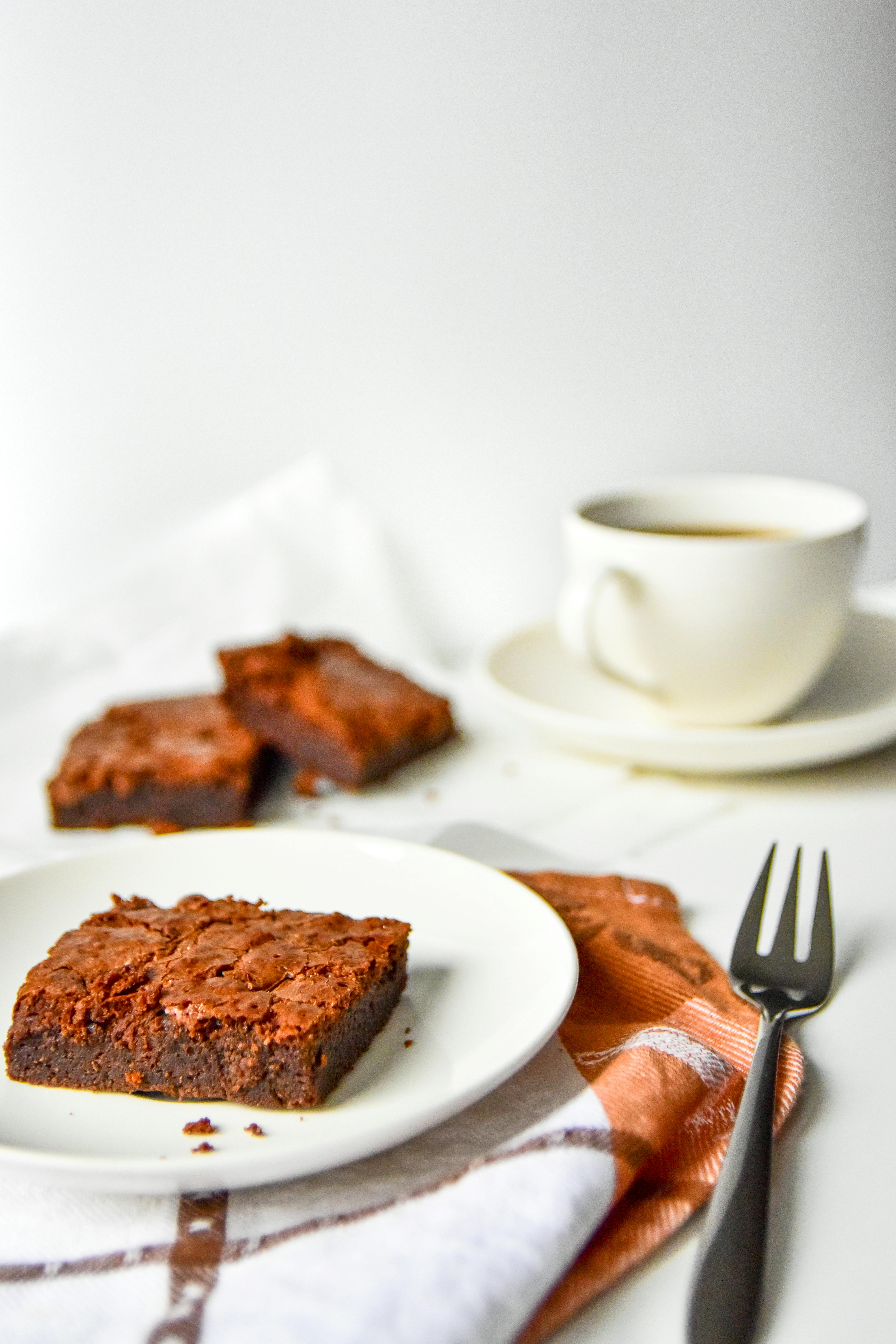 Enjoy a delightful brownie served with coffee for a perfect dessert moment.