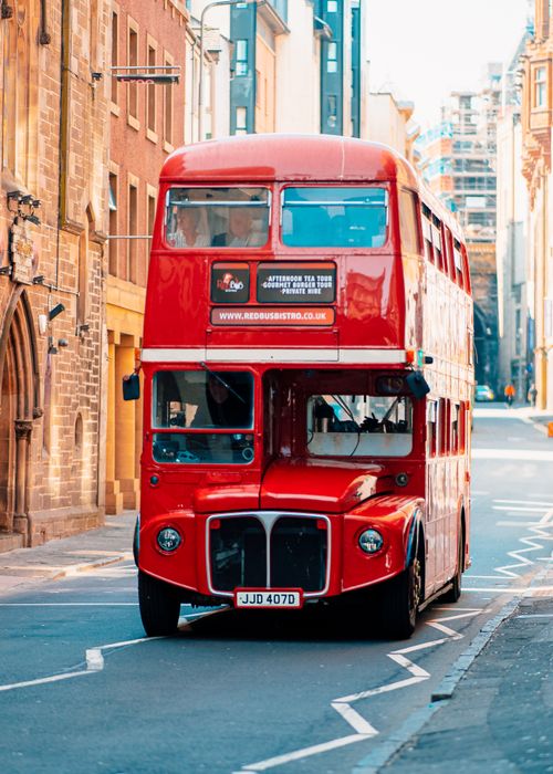Free Red double decker bus navigating the charming historic streets of Edinburgh, Scotland, showcasing urban transportation. Stock Photo