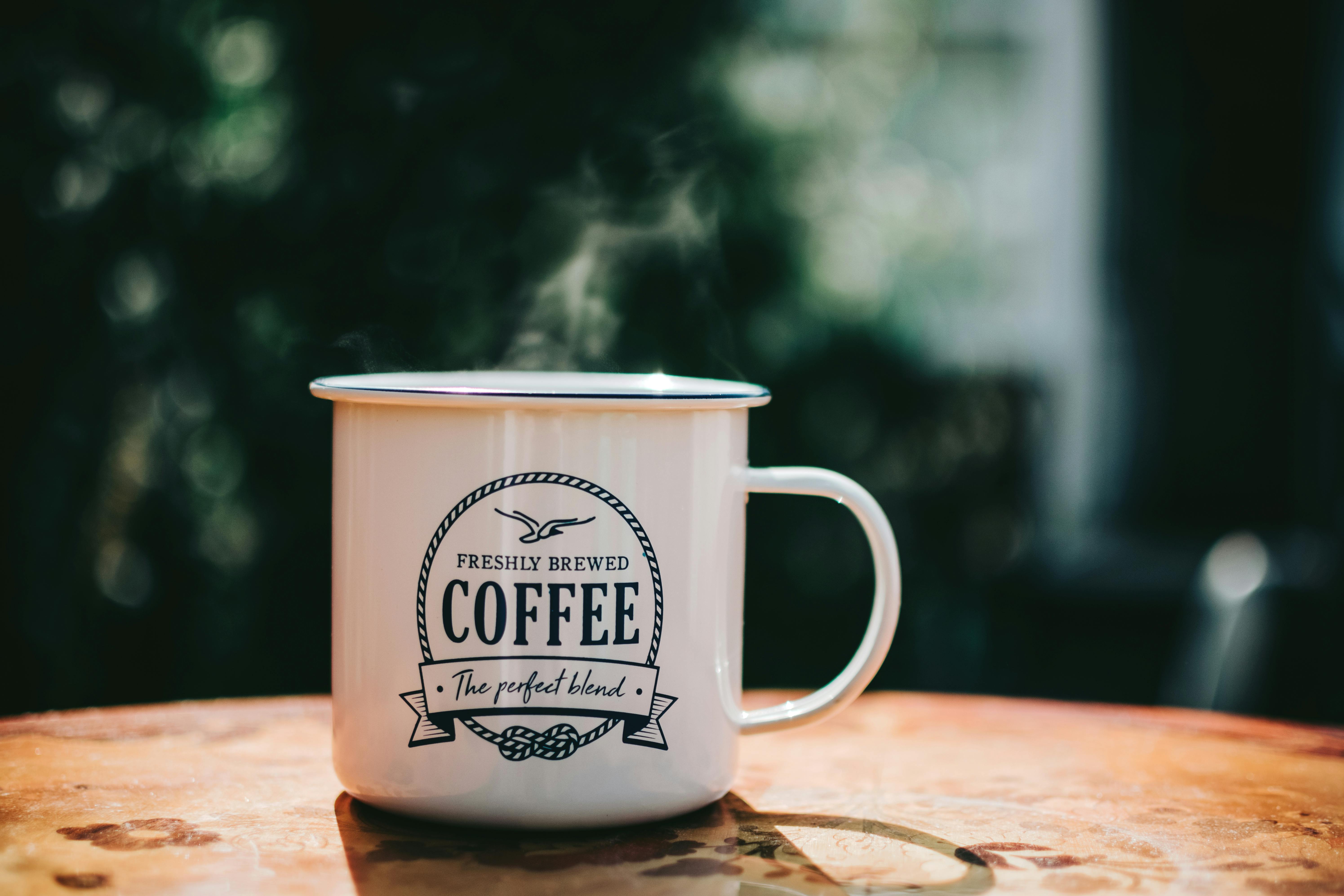 white coffee mug on brown surface