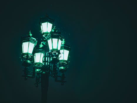 A close-up view of an antique street lamp glowing vividly at night.