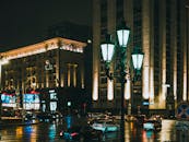 夜晚，城市街道上车流拥挤，路灯闪烁，映衬着现代建筑