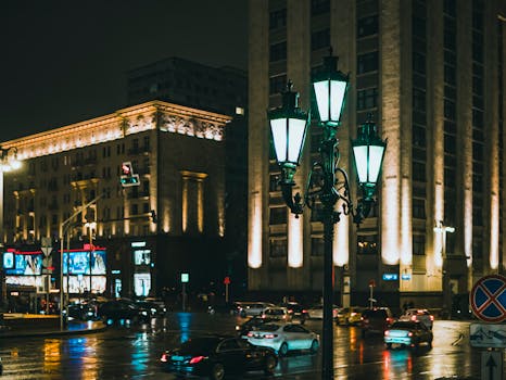 夜晚，城市街道上车流拥挤，路灯闪烁，映衬着现代建筑