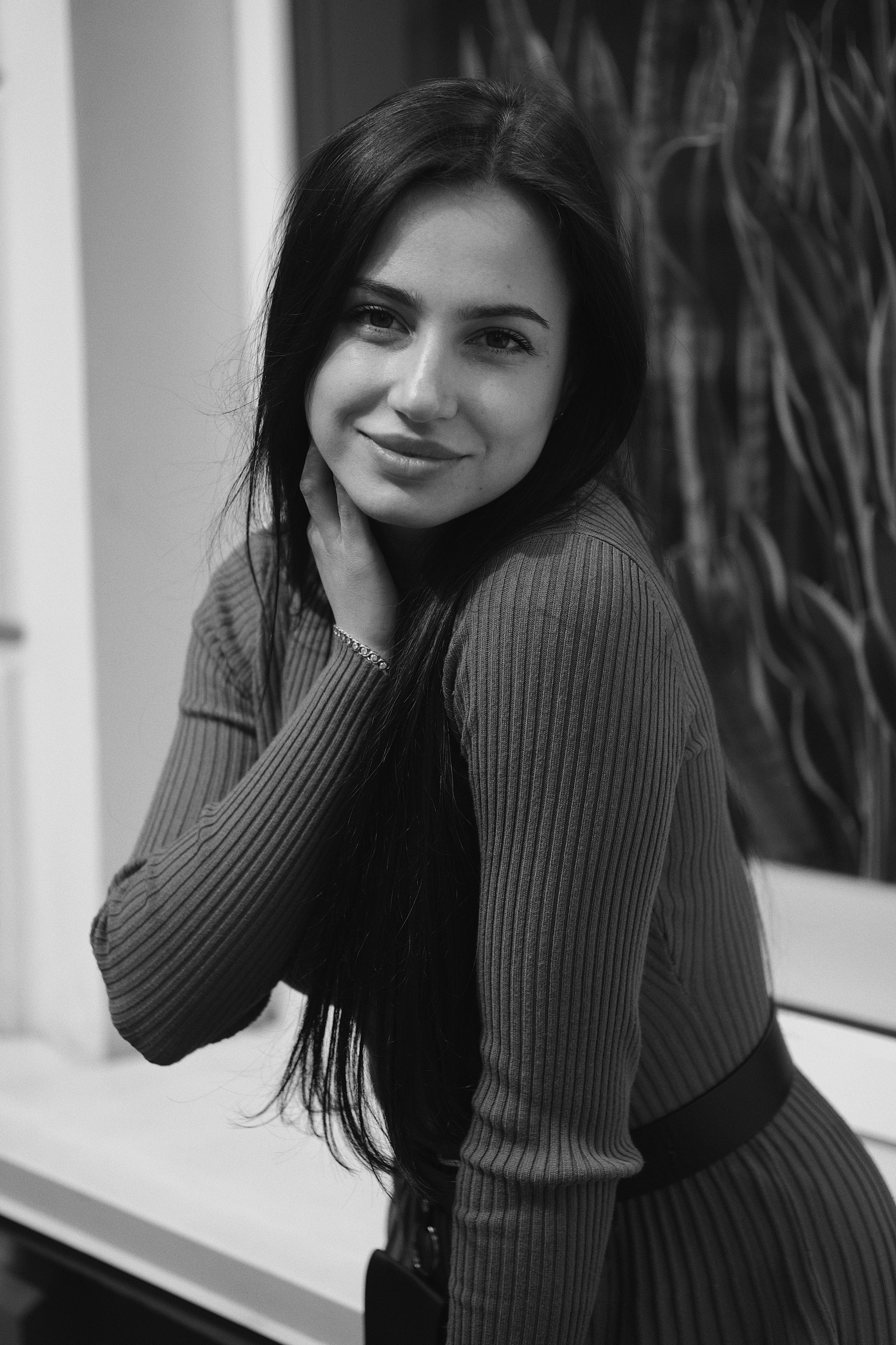 A monochrome portrait featuring a woman in a stylish dress, exuding elegance and confidence.