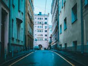 狭窄的城市小巷里，古老的建筑和停放的汽车环绕四周