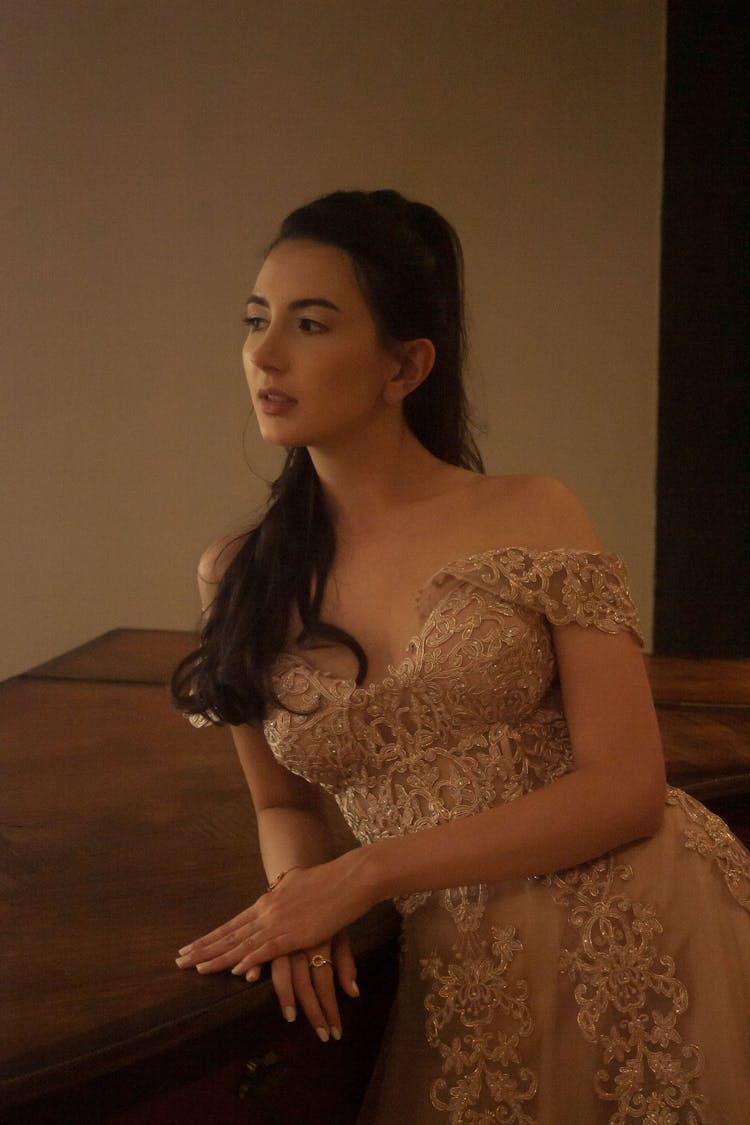 Woman In Brown Lace Gown Leaning On Table 