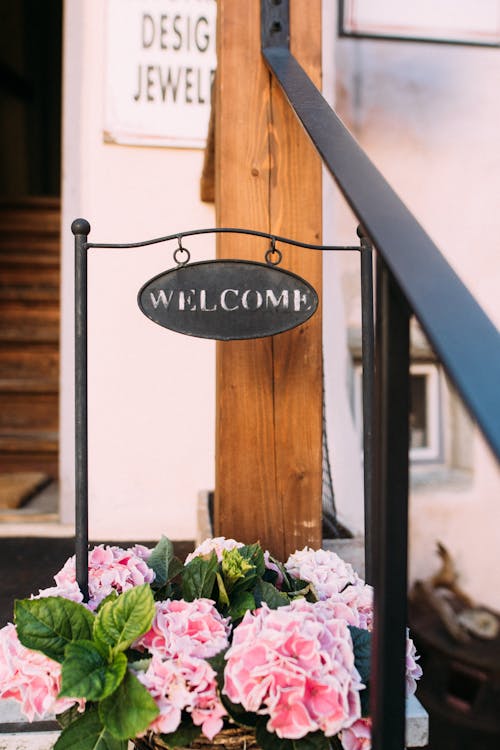 Welcome Sign and Flowers in a Pot 