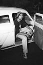 Young Man Sitting in Open Door of White Vintage Car Door
