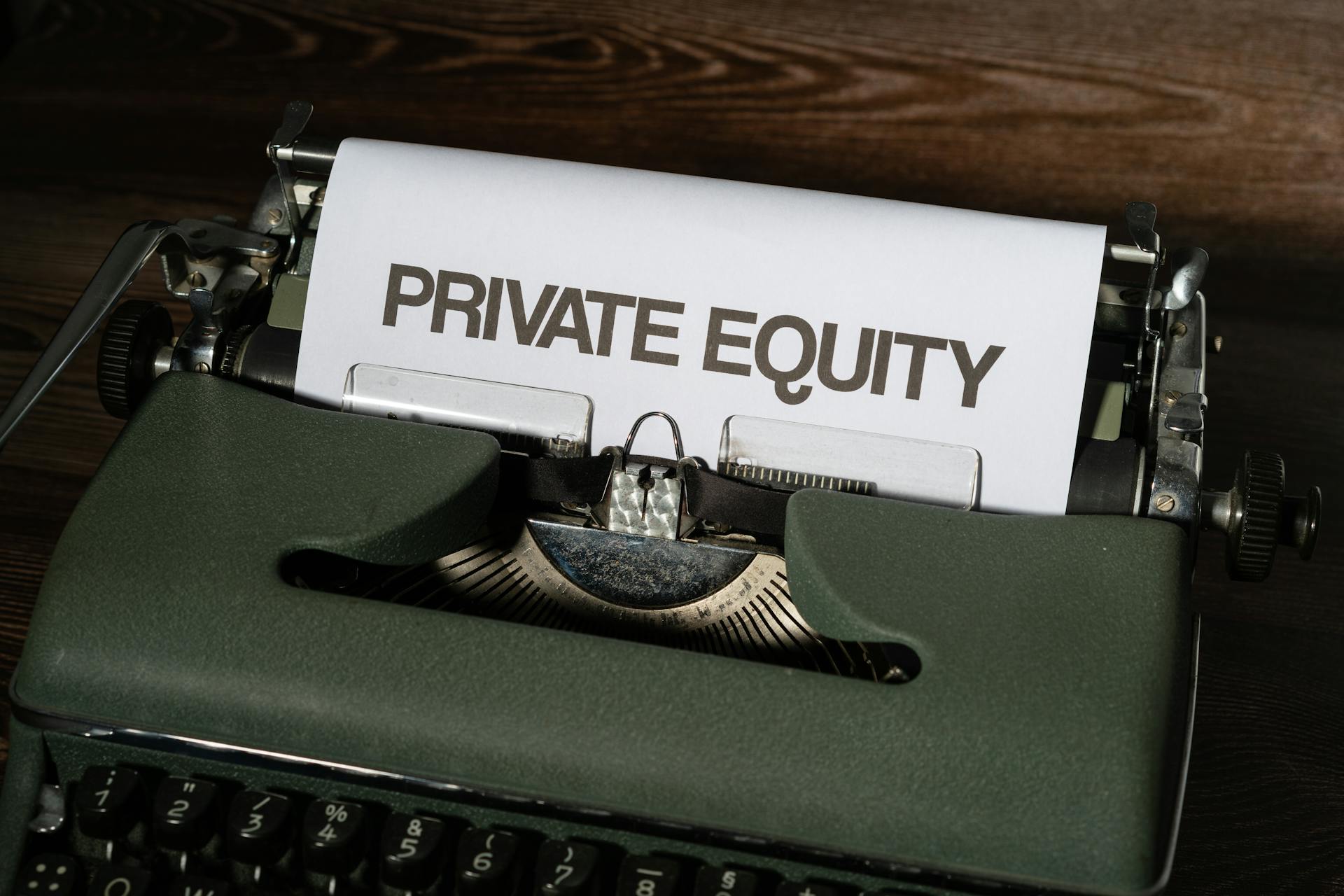 Close-up of a vintage typewriter with paper displaying 'Private Equity'.