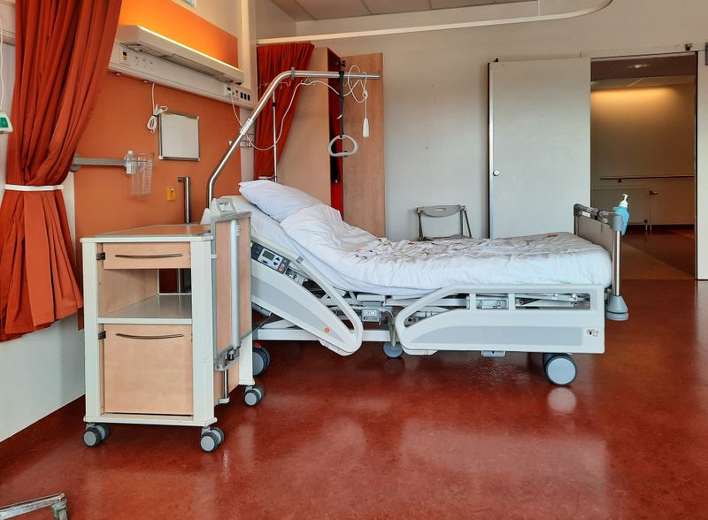 A clean and modern hospital room equipped with an adjustable bed and medical equipment