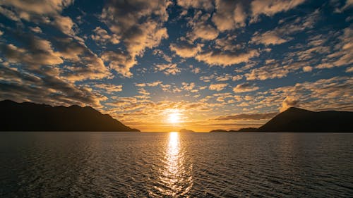 Silhouette of Mountains near the Sea during Sunset