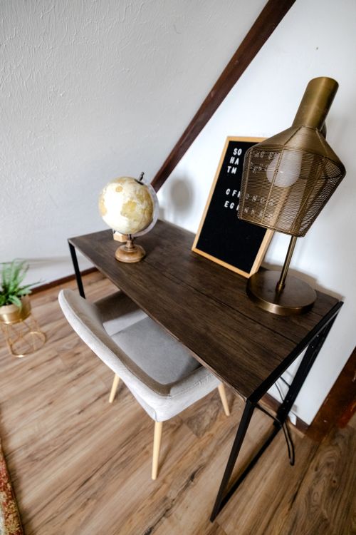 Free A stylish home office setup featuring a globe, lamp, and letter board on a wooden desk. Stock Photo