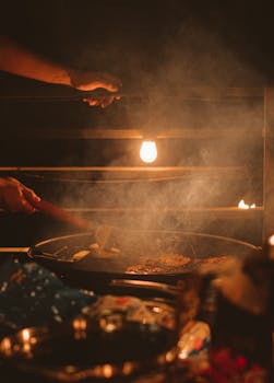 Warm, atmospheric cooking scene with hands preparing food in rustic lighting.