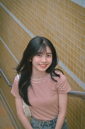 Young woman smiling in a striped top, photo by Lee Trinh on Pexels