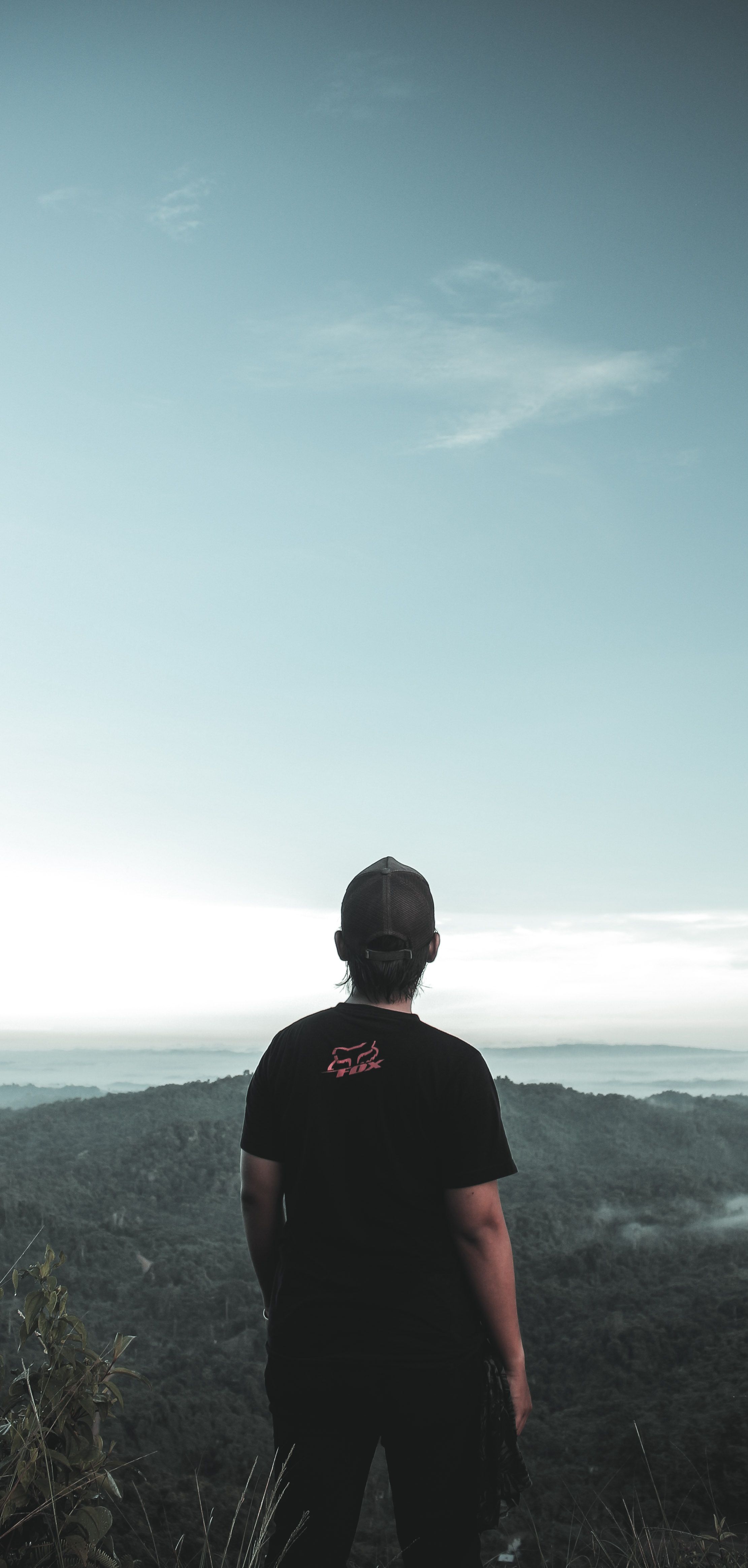 黄昏时分，一名戴帽子的男子剪影俯瞰着山景