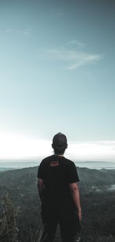 黄昏时分，一名戴帽子的男子剪影俯瞰着山景