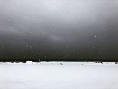 Snow Covered Field Under Gray Sky