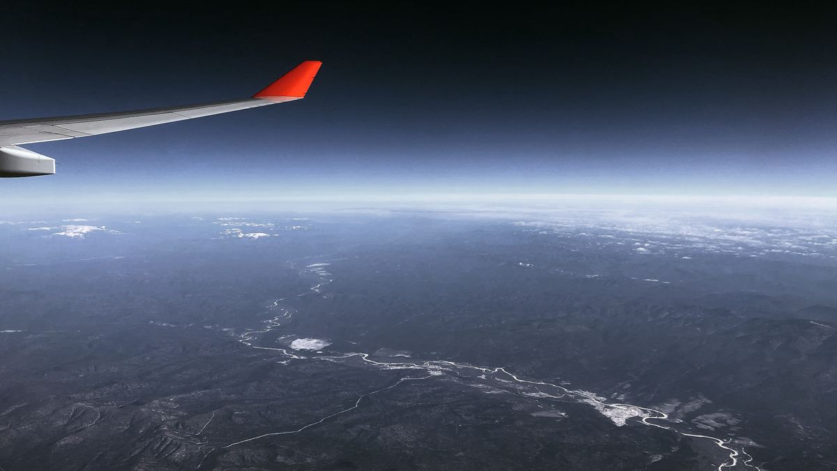 Breathtaking aerial view of mountains and river from an airplane window.