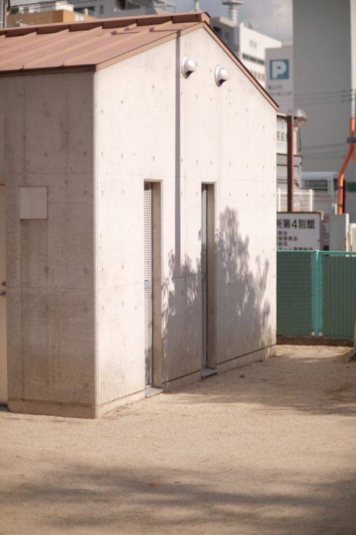 Free A modern minimalist concrete building exterior with a shadowed facade in an urban setting. Stock Photo