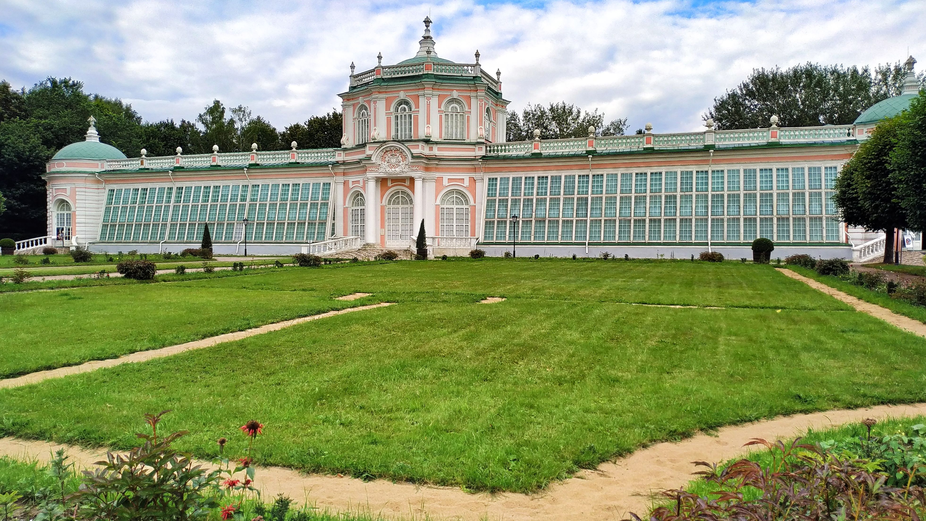 Outside of a large elegant building with orangery attached