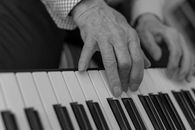 Gray Scale Photo of Person Playing Piano