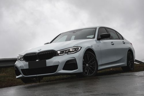 Free Silver car parked on a roadside with a cloudy sky backdrop, highlighting its sleek design. Stock Photo