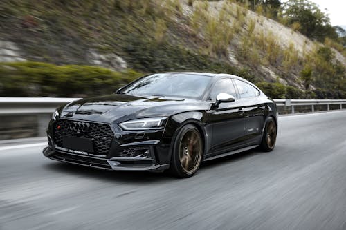 Black Car Driving Fast on Asphalt Road