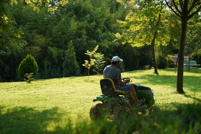 Riding mower cutting a large green lawn