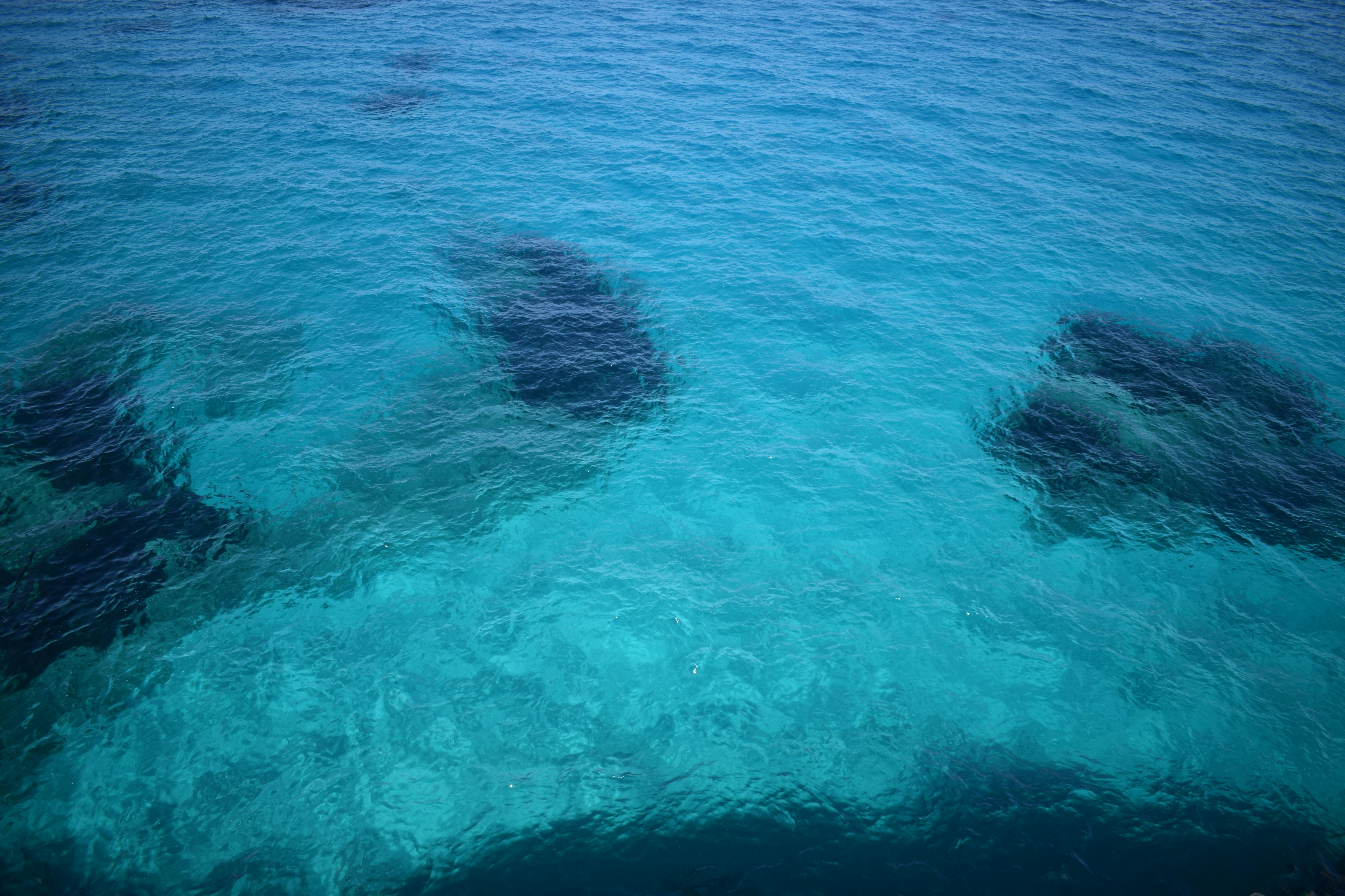 Gratis Ripresa accattivante delle limpide acque blu dell'oceano con formazioni marine visibili. Foto a disposizione