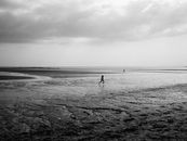 Grayscale Photo of Person Walking on Beach