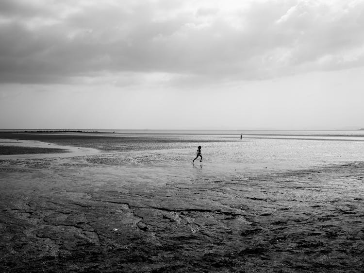 Silhouette Of Running Child On Beach