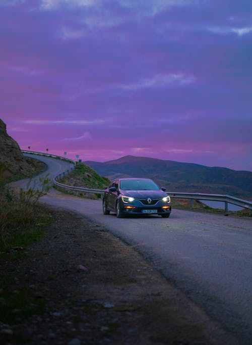 Renault on Road under Clouds at Dusk